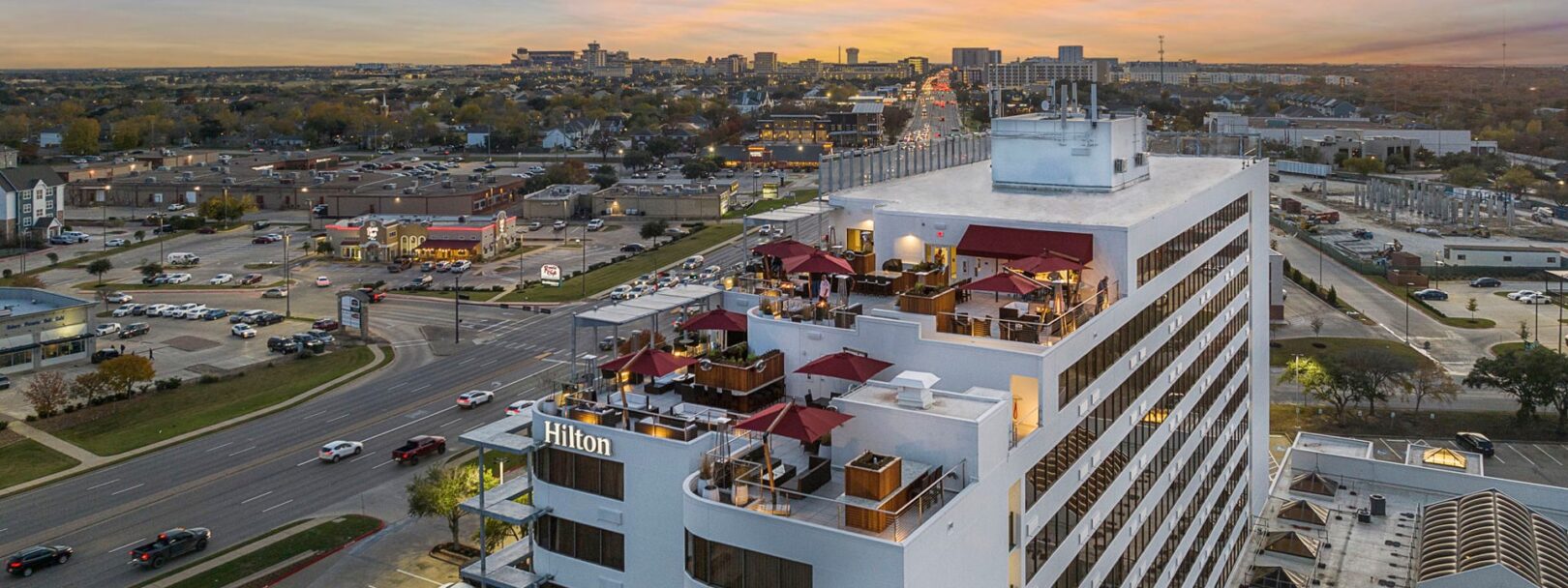 Aerial view of Reveille Rooftop Bar with the skyline of Texas A&M University in the background.